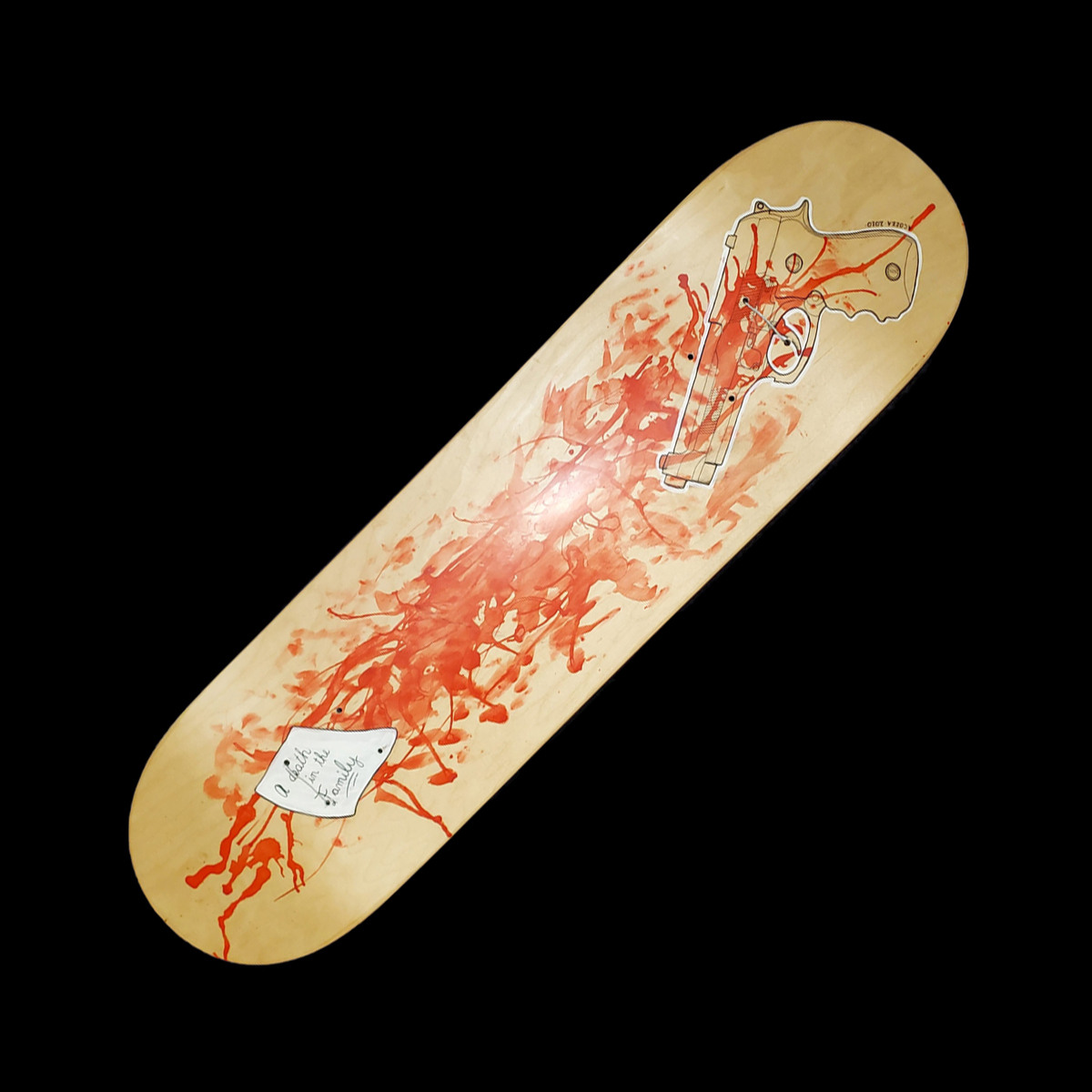 A transparent outline of a 9mm beretta sitting atop of smeared up red, with a white sticky note on top that says A Death In The Family
