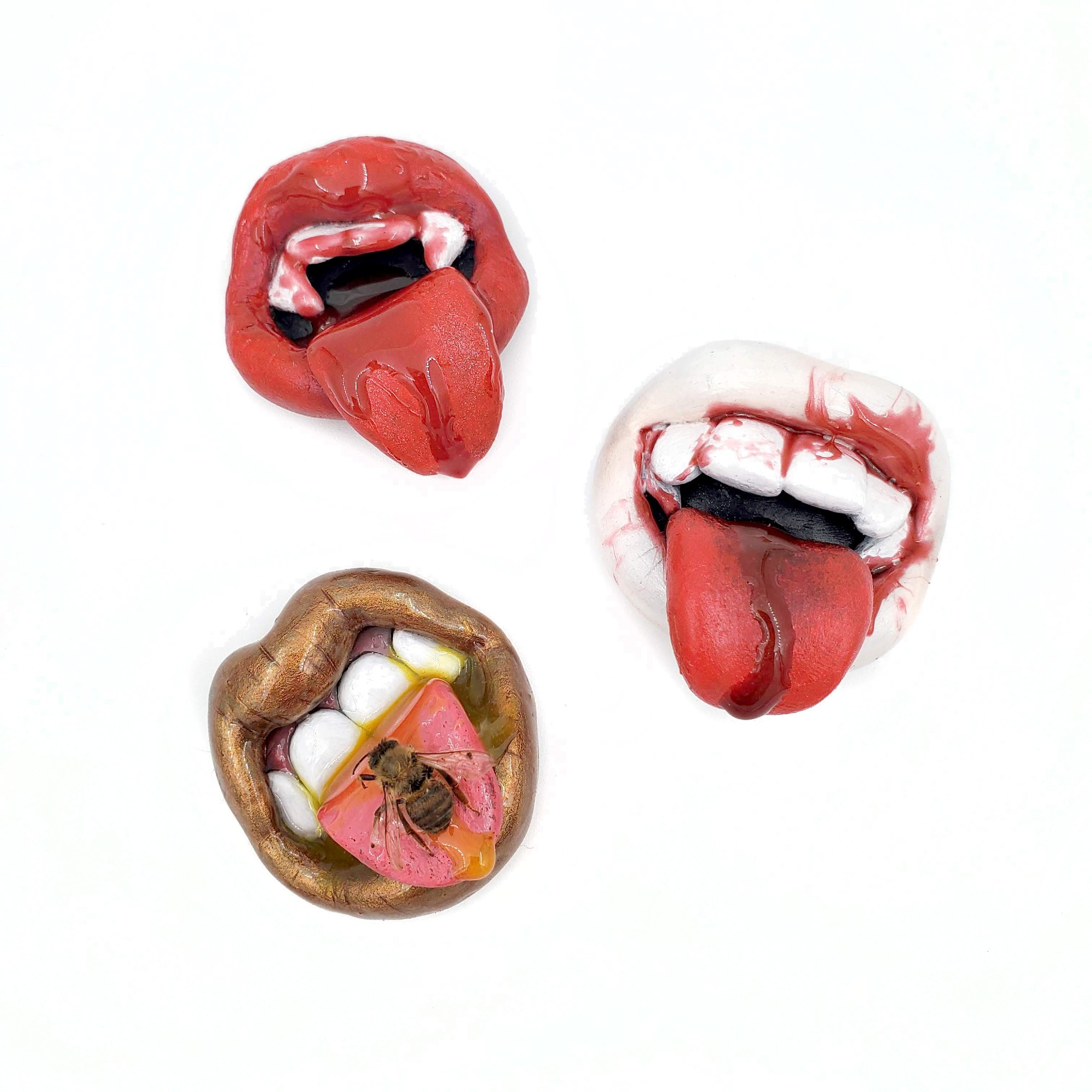 Three polymer moths on a white background with tongues extended. The first is a red mouth with fangs. The second is a white mouth with fangs. The third is a copper mouth with honey and a honeybee on the tongue.